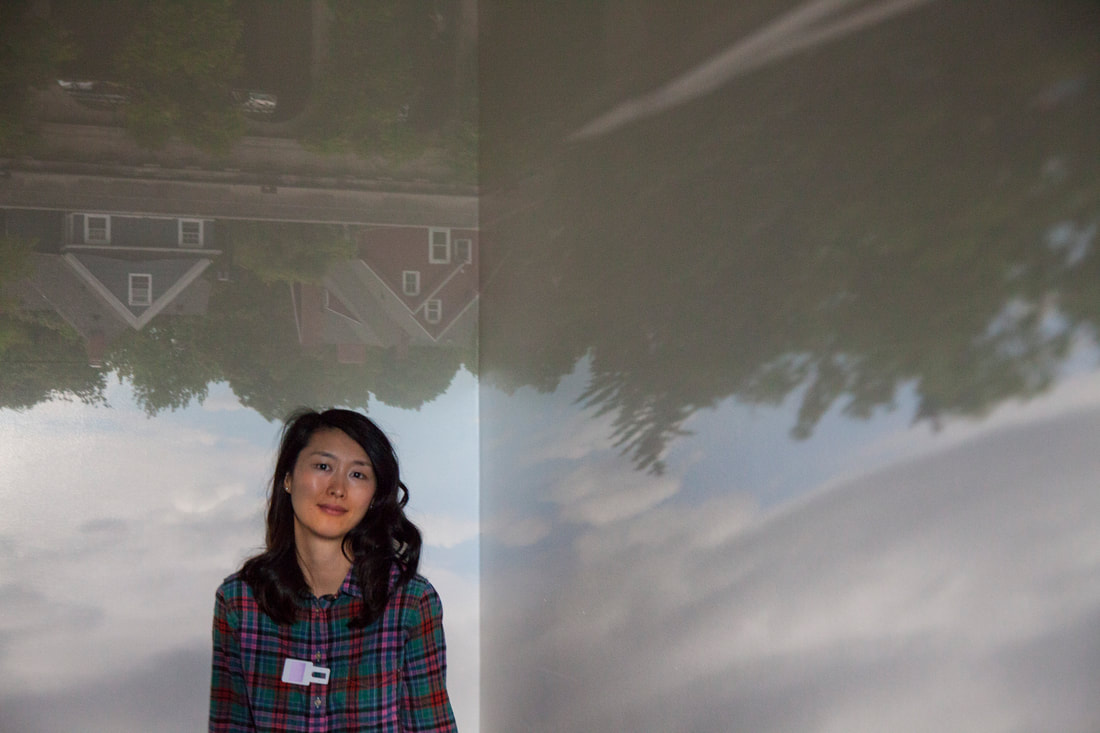 Jackie Chi sitting in a room at the George Eastman Museum that was turned into a camera obscura