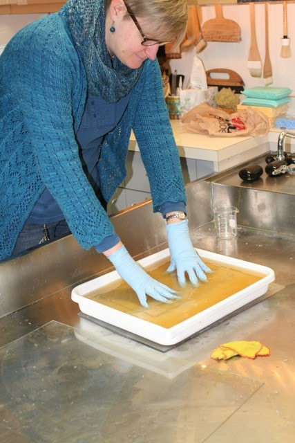 Renee bathing paper in a paper conservation lab